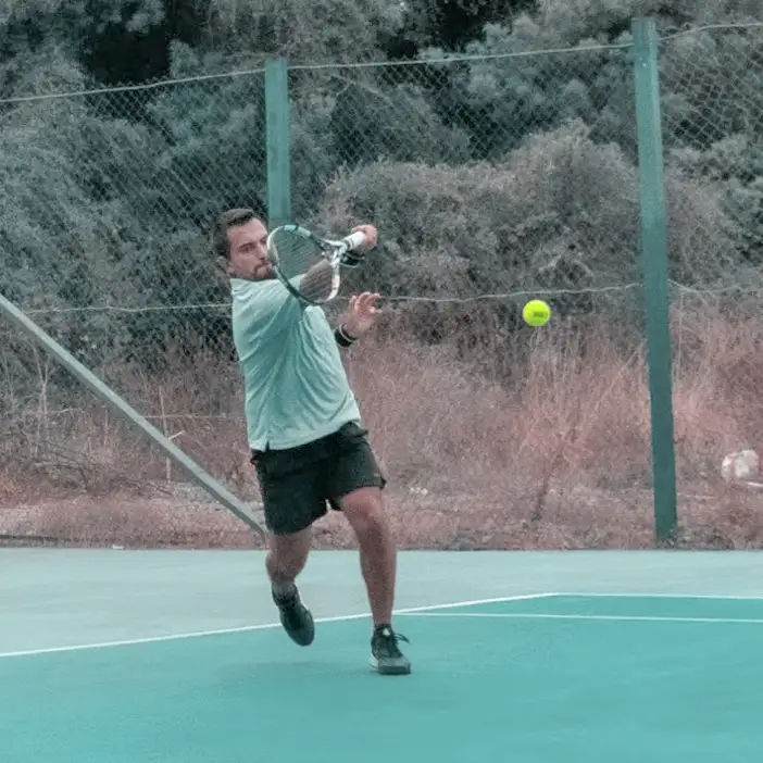 foto en donde aparece un jugador generando spin al golpear la pelota con cuerda con caras